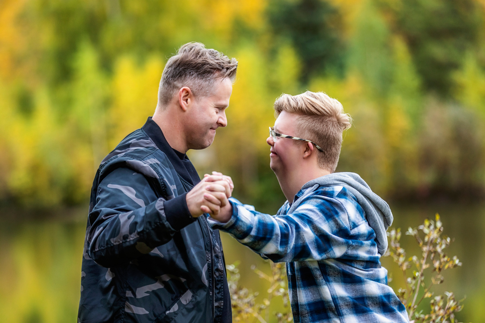 A young man with Down Syndrome and his father enjoying each other's company